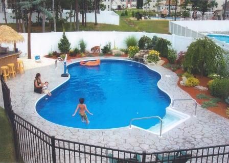 A woman in a bikini is swimming in a large swimming pool