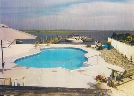 A large swimming pool with a boat in the background