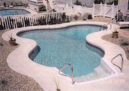 A large swimming pool with a white fence around it