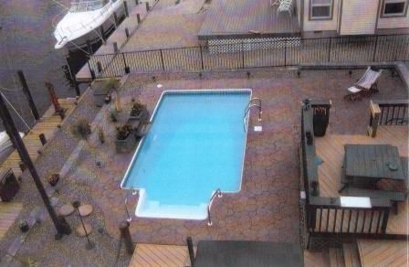 An aerial view of a swimming pool with a boat in the background