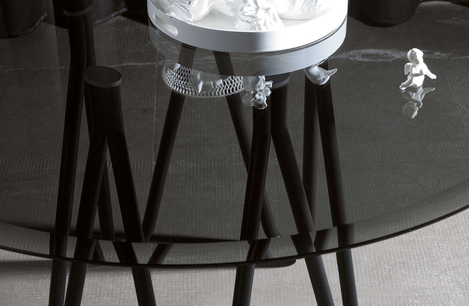 Il tavolo Meduse Vetro ricorda le simmetrie di questi esseri radiosi, raggiati, traslucidi, forme di vita quasi liquida nel liquido, così flessuose eppure così regolari. Struttura in metallo verniciato e piano in vetro fumè (disponibile anche in marmo).