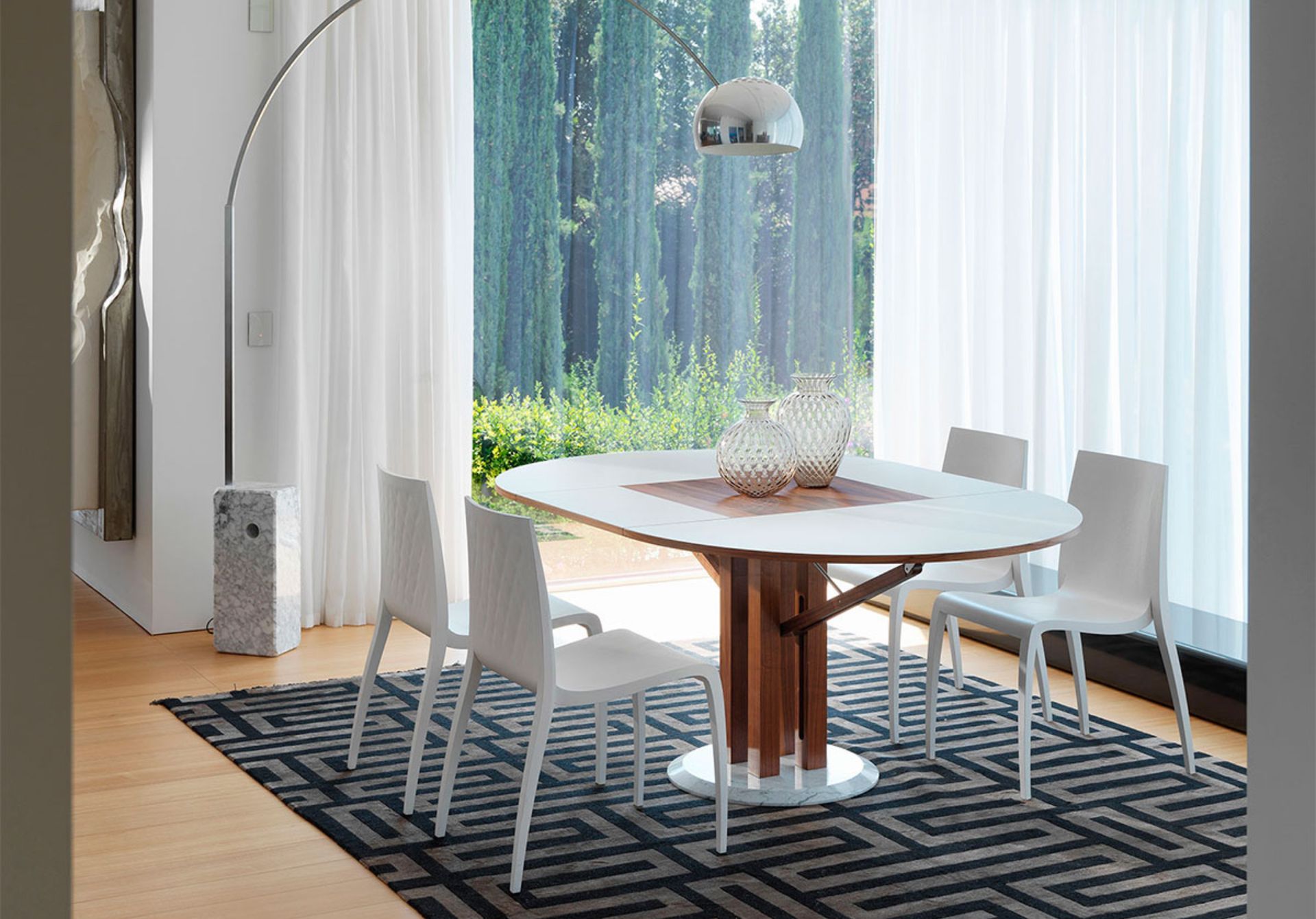 Flower è il risultato di un’entusiasmante collaborazione con due Maestri del design mondiale, nata da una sfida: realizzare un tavolo rotondo allungabile che risultasse bello sia da chiuso che da aperto. I piani scorrono senza l’utilizzo di guide allungabili, grazie ad una soluzione tecnica che diventa anche estetica: un braccetto mobile che ricorda una gru romana. L’allunga fuoriesce e si apre come lo sbocciare di un fiore, dimostrando che l’estetica è la naturale conseguenza del buon design, concepito come ricerca tecnica della semplicità e della funzionalità.