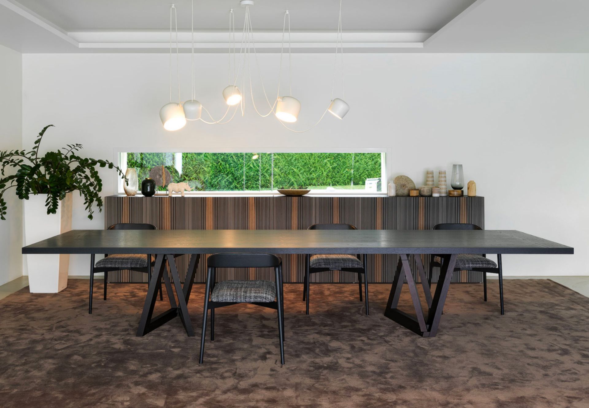 Mentre stava lavorando alla costruzione di un telaio composto da due superfici intersecanti tra loro, Dror “inciampa” in una scoperta affascinante: la materia, tagliata sapientemente e combinata assieme genera una nuova forma, un elemento strutturale nuovo che, aperto, crea una base triangolare stabile ed indipendente. Nel QuaDror 03 questa base si raddoppia dando forma a un tavolo che non passa certo inosservato: con i suoi 420 cm di lunghezza è un tavolo ampio e funzionale, caratterizzato da un design imponente. Il gioco di equilibri dona a questo tavolo un aspetto sofisticato, adatto a divenire il protagonista dell’ambiente.