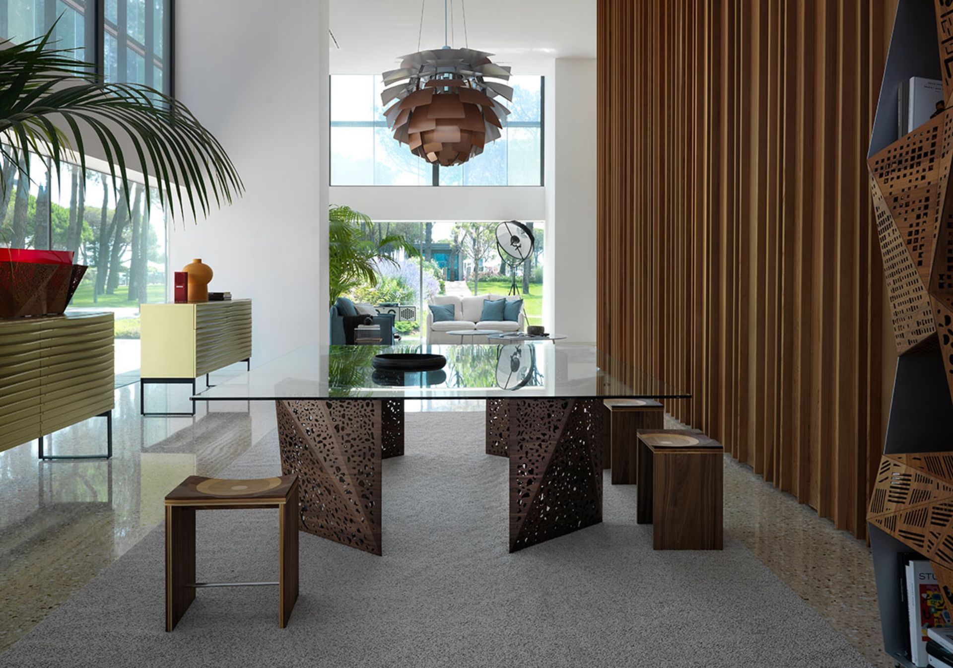 L’originalità e la lavorazione delle gambe sono le vere protagoniste del tavolo Riddled, che riprende il tema della porosità presente in molte architetture di Steven Holl. I sottilissimi fogli di legno, piegati grazie a delle incisioni laser, rendono ancor più spettacolare questo progetto, che sembra una sfida alle leggi della fisica. Le due gambe, simili a scultorei origami, permettono alla luce interna di trapassarle in una vera e propria esplosione di giochi d’ombre.