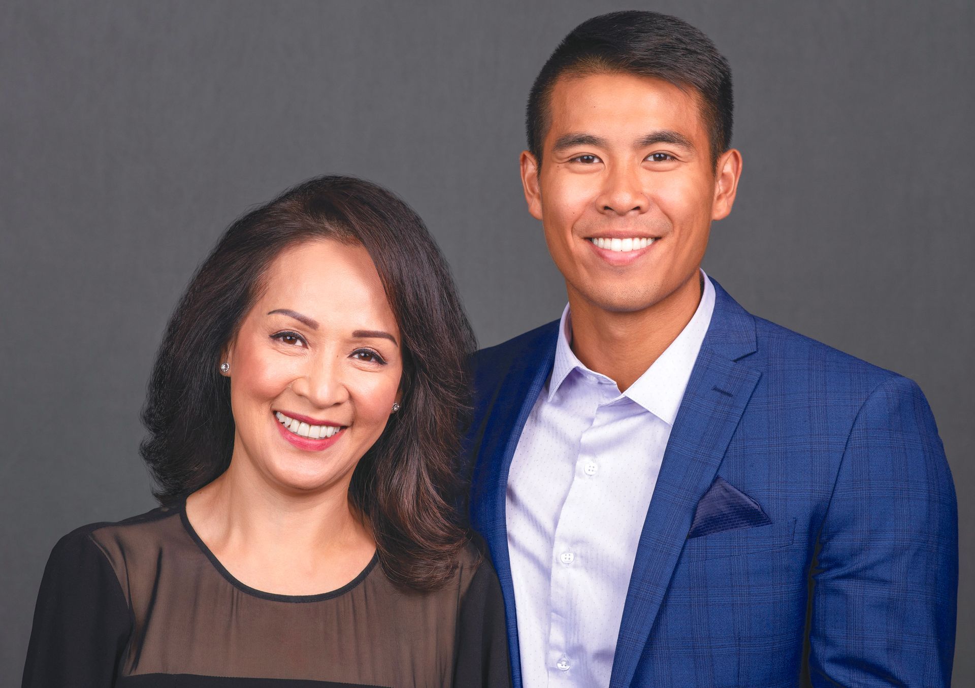A man and a woman are posing for a picture and smiling for the camera.