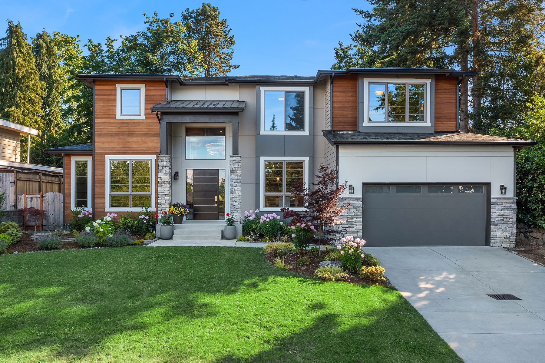A large house with a lush green lawn and a gray garage door.