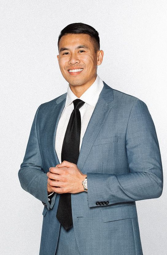 A man in a suit and tie is smiling for the camera.