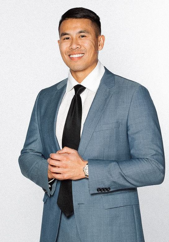 A man in a suit and tie is smiling for the camera.