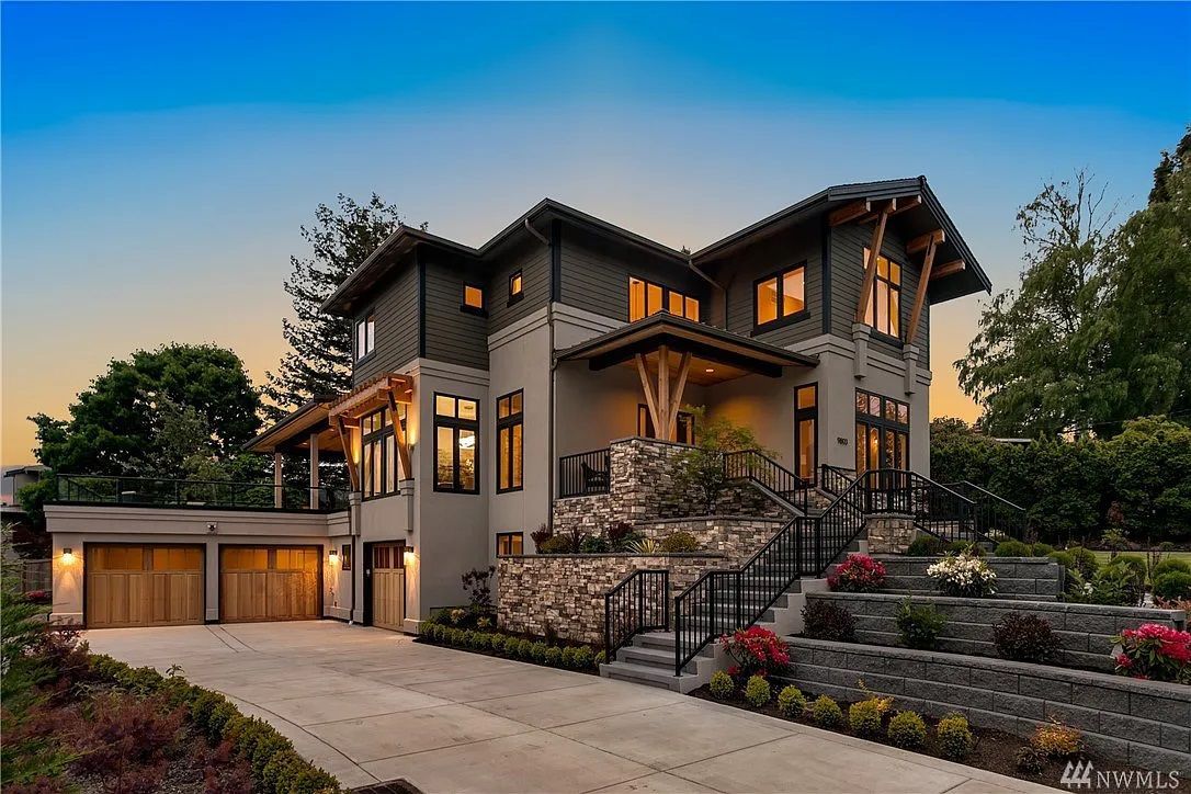 A large house with a lot of windows is sitting on top of a hill.