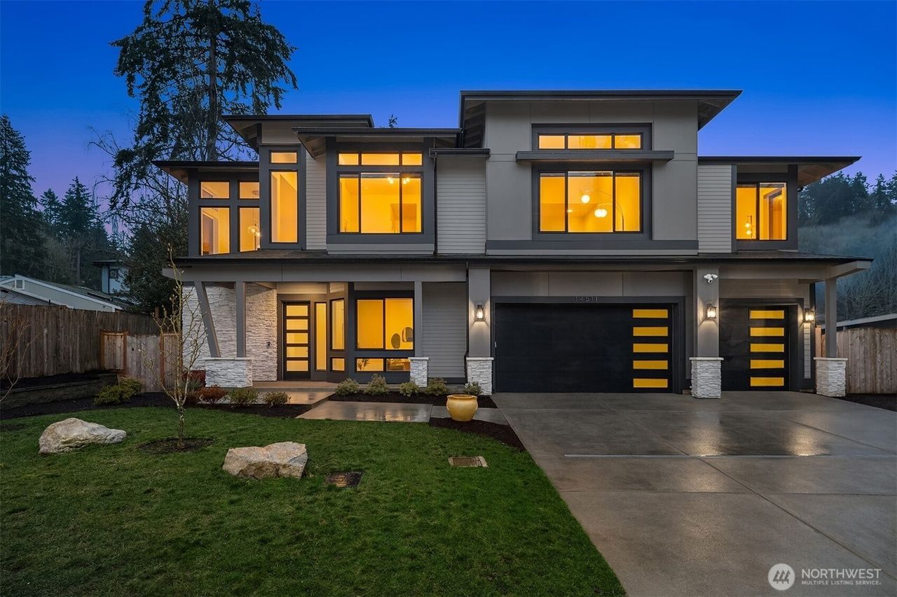 A large house with a lush green lawn and a gray garage door.