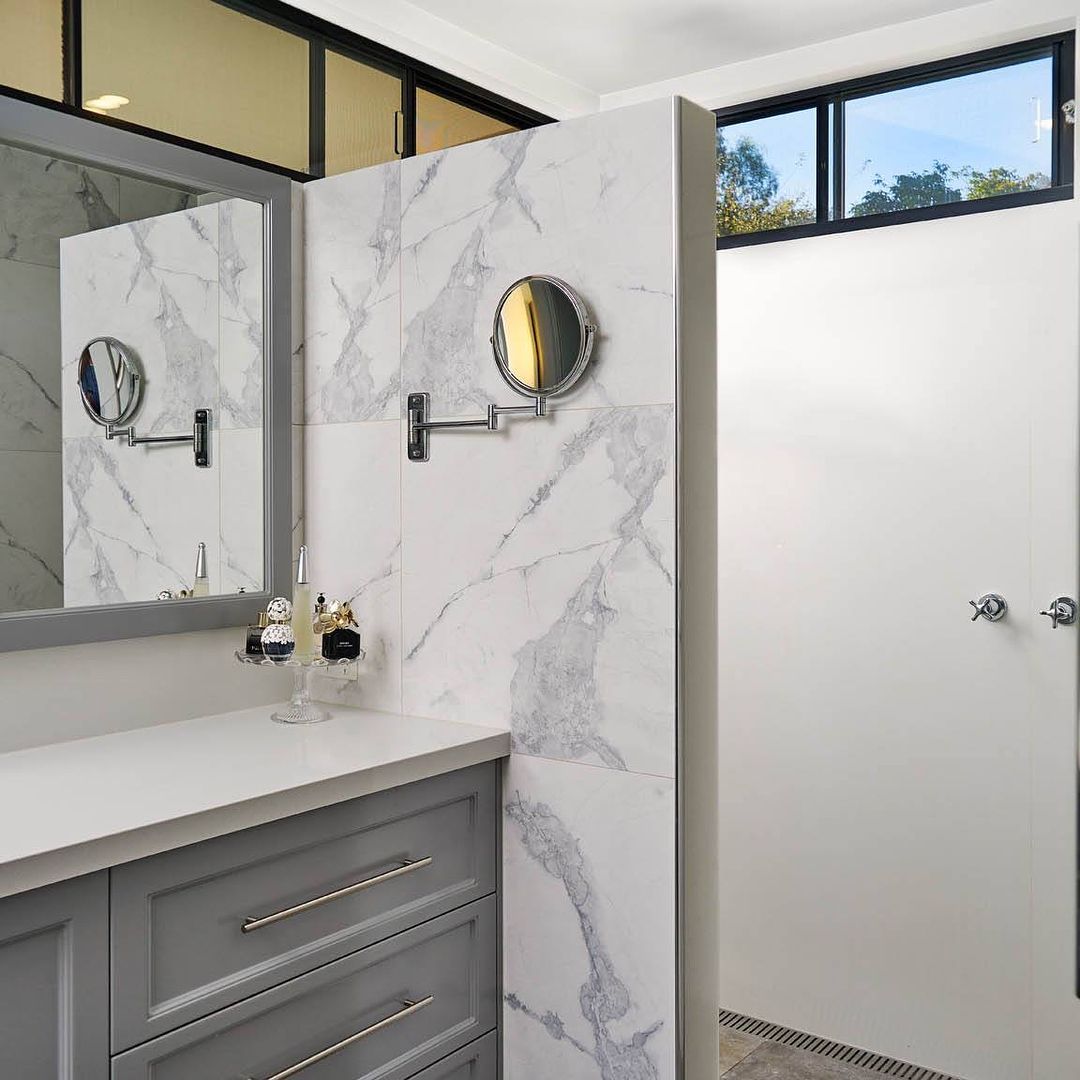 A Bathroom With A Sink, Mirrors, And A Window — Wards Kitchens in Berkeley Vale, NSW