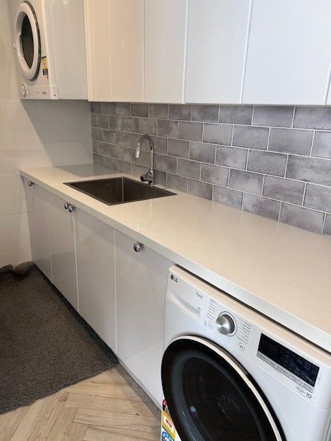 A Laundry Room With A Black And White Checkered Floor — Wards Kitchens in Berkeley Vale, NSW