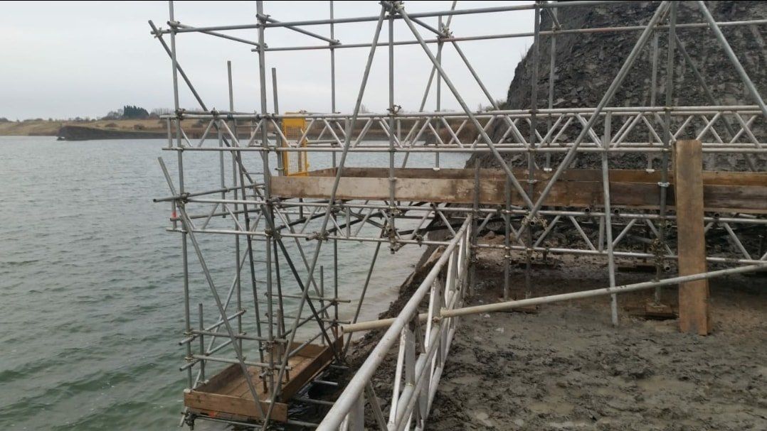 access to water line with scaffolding going across water and land