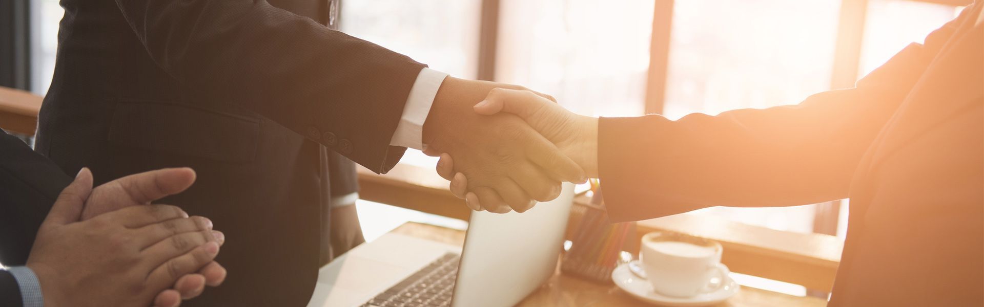 Client and estate planning attorney finalize contract with handshake in professional setting.