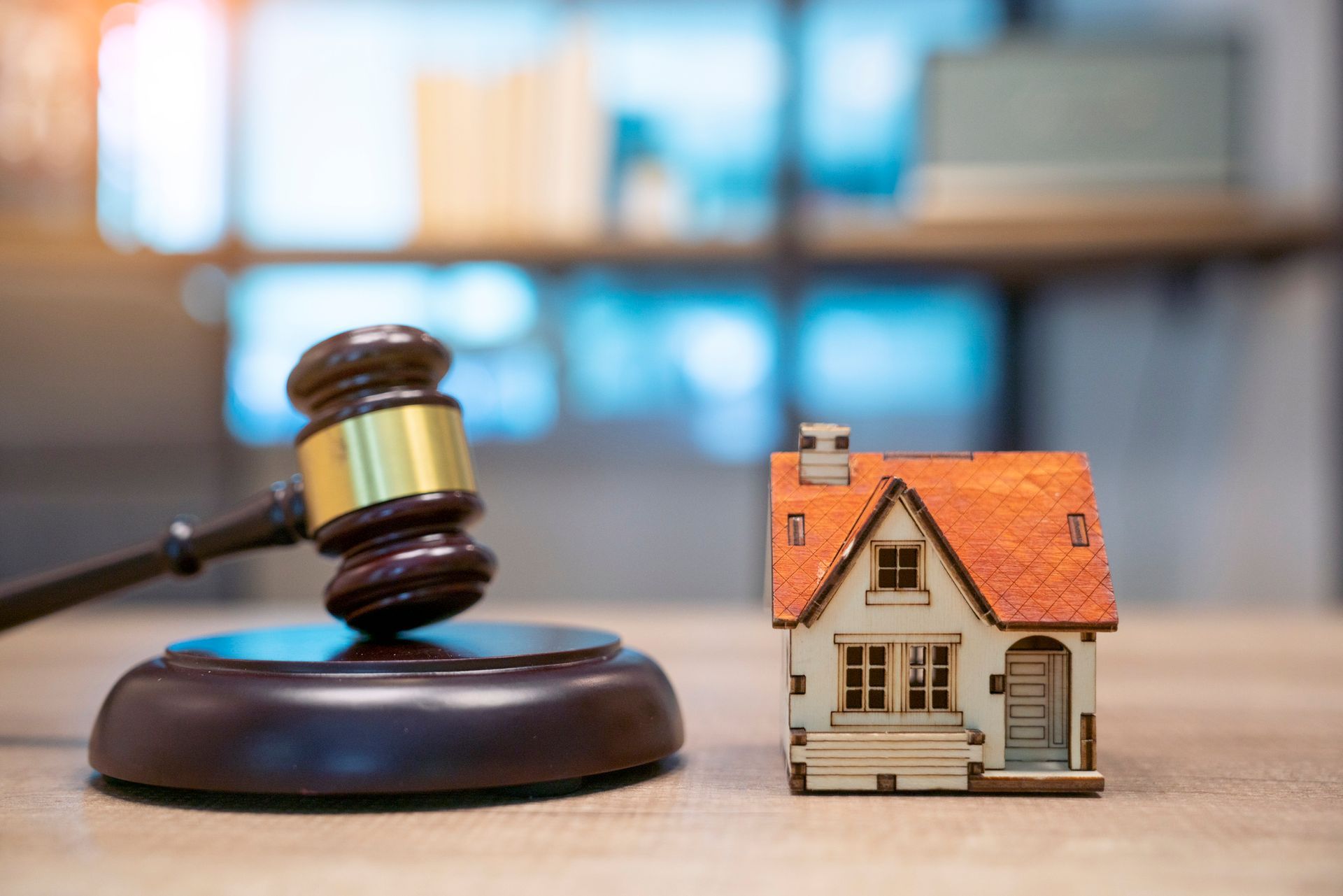 Gavel beside miniature house representing legal advice from an estate planning attorney.