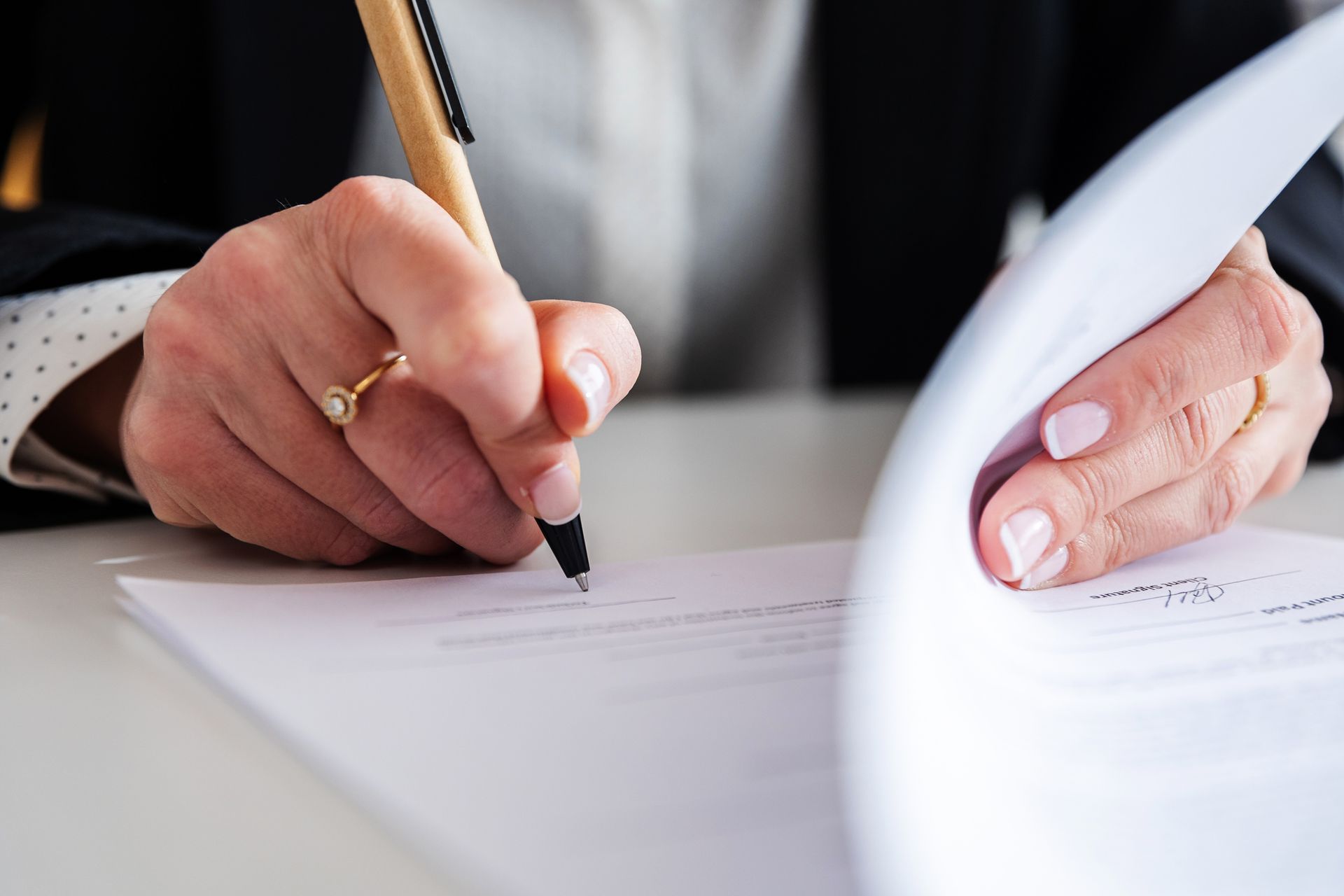Businesswoman signing a contract at office desk.