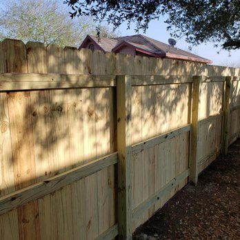 A wooden fence is sitting in front of a house.
