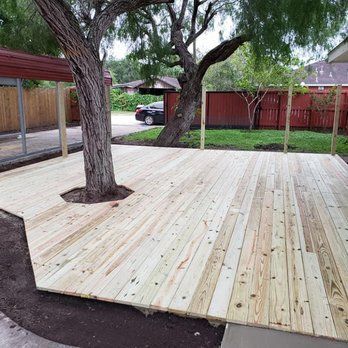 A wooden deck with a tree in the middle of it.
