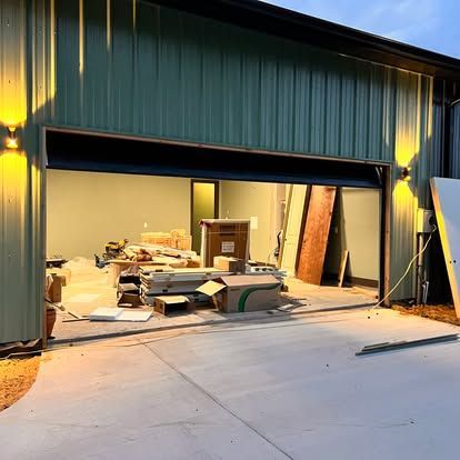 A garage door is open and a lot of boxes are in it.