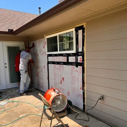 A man is working on the side of a house.
