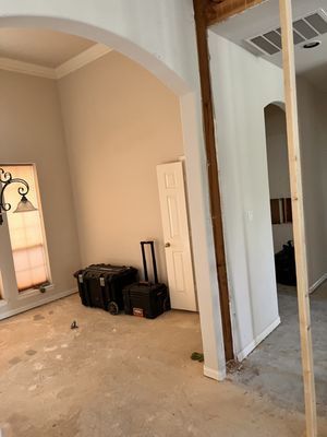 A living room with a wooden post in the middle of it.