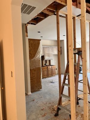 A ladder is sitting in the middle of a room in a house under construction.