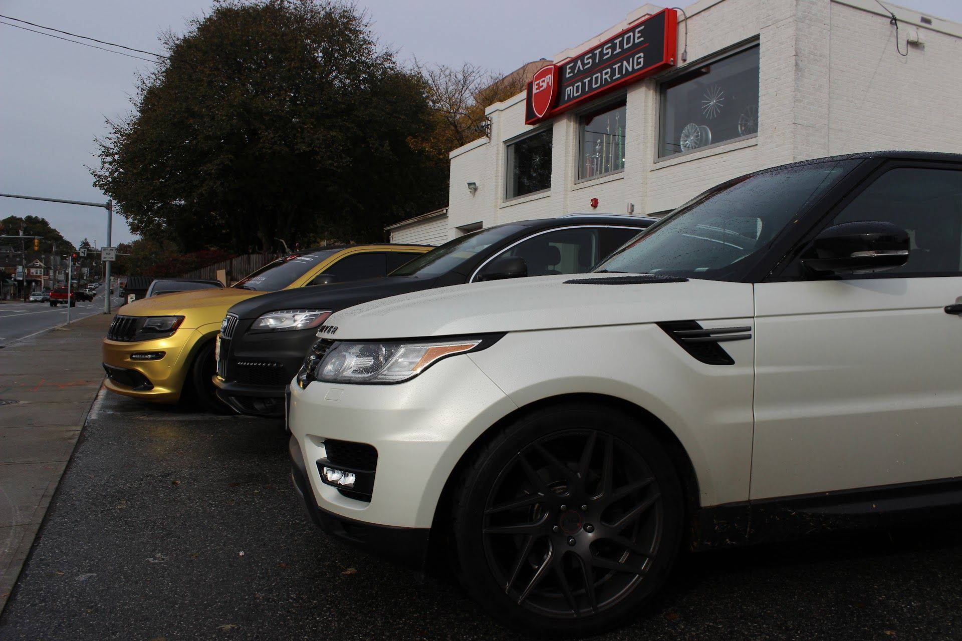 White And Yellow Luxury SUVs Parked Outside Auto Repair Shop In Waltham, MA | Eastside Motoring