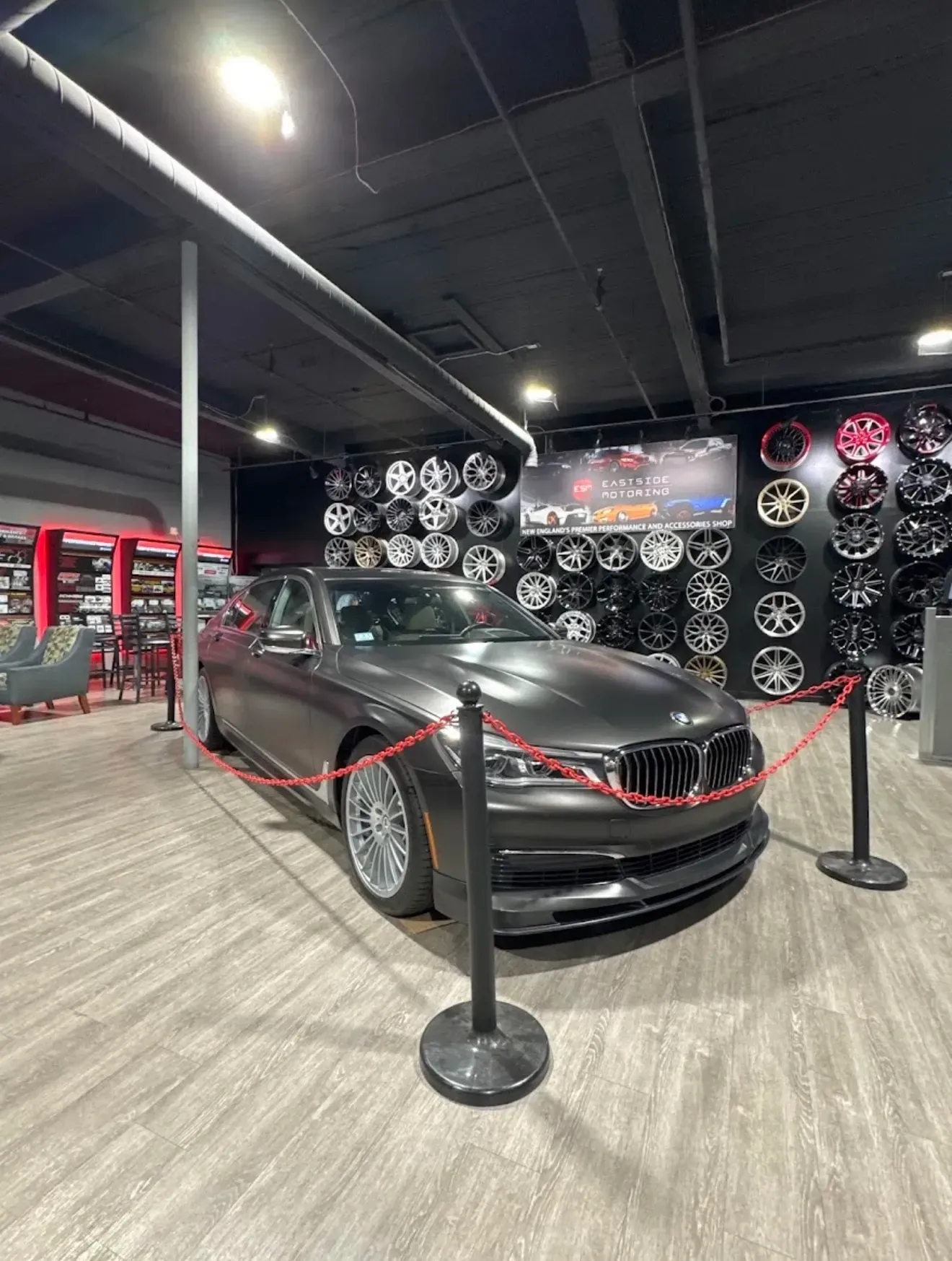 Dark gray BMW sedan on display inside a wheel shop | Eastside Motoring