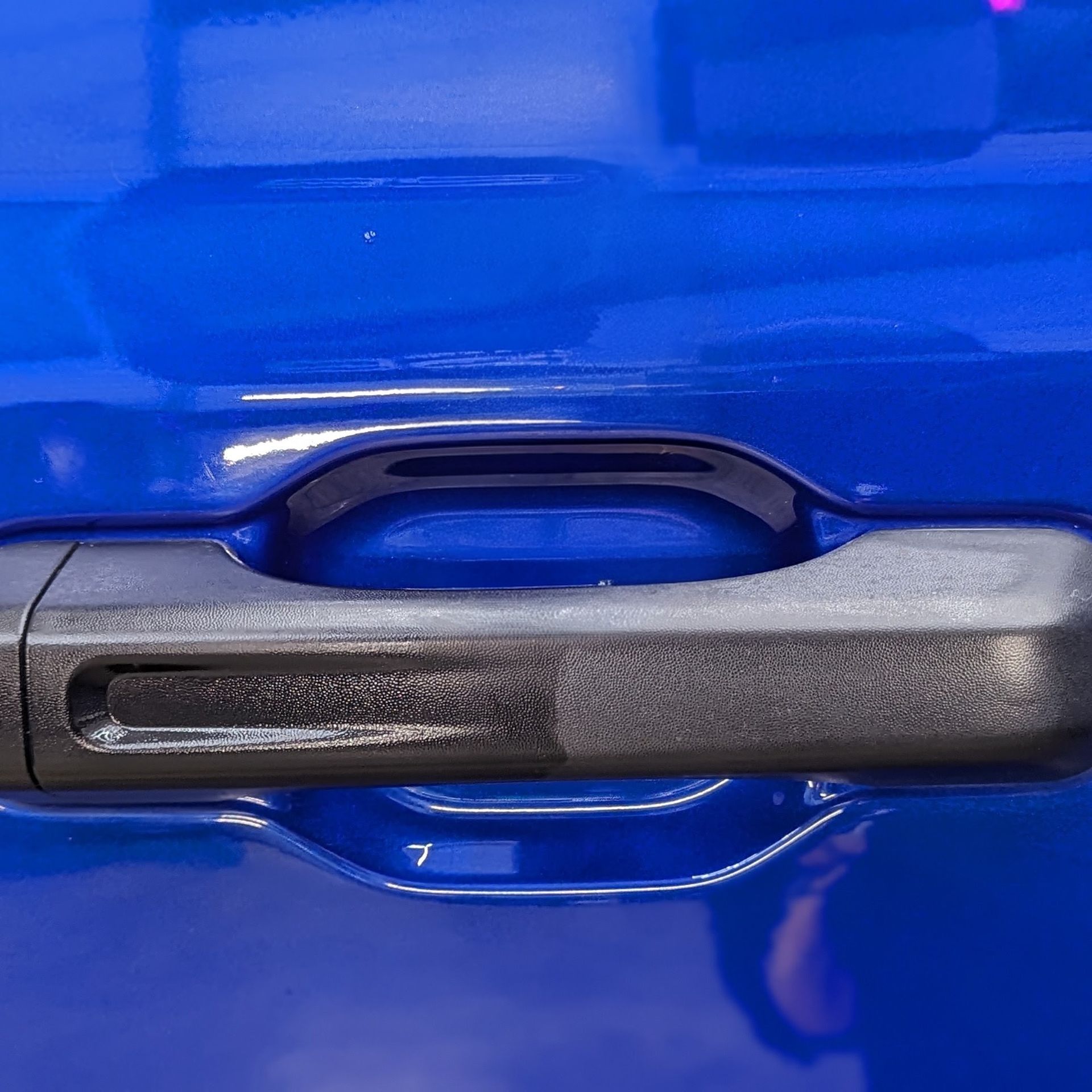 Blue car door with a black handle.