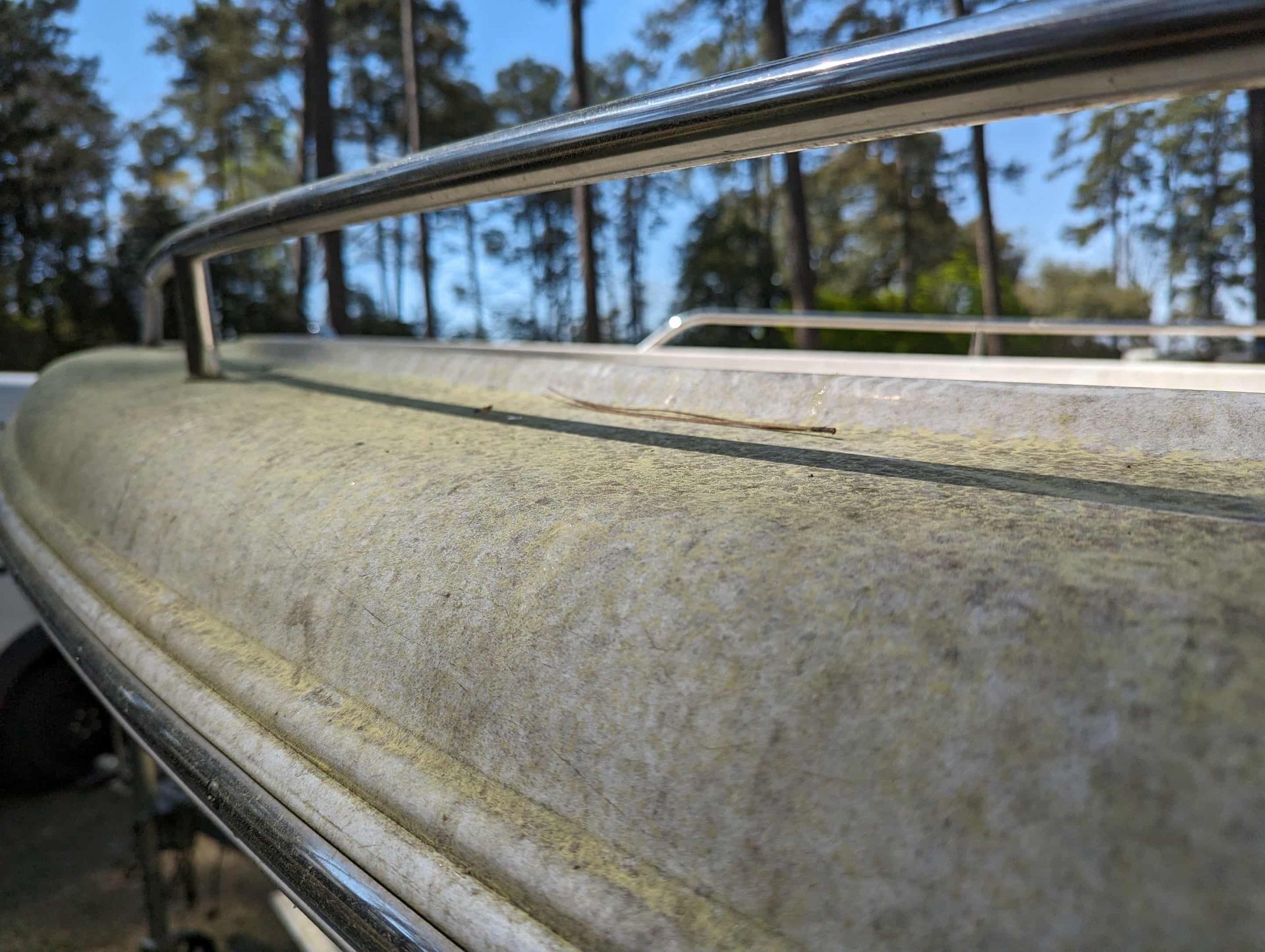 Boat deck with a weathered, textured surface and a metal railing.