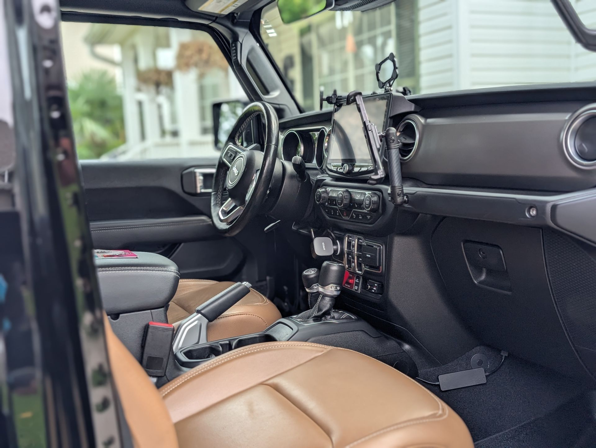 Interior of a black Jeep with brown leather seats and a black dashboard; visible steering wheel and center console.