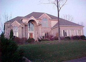 A large brick house with a tree in front of it