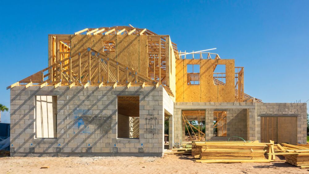 A house is being built with wooden beams and bricks.