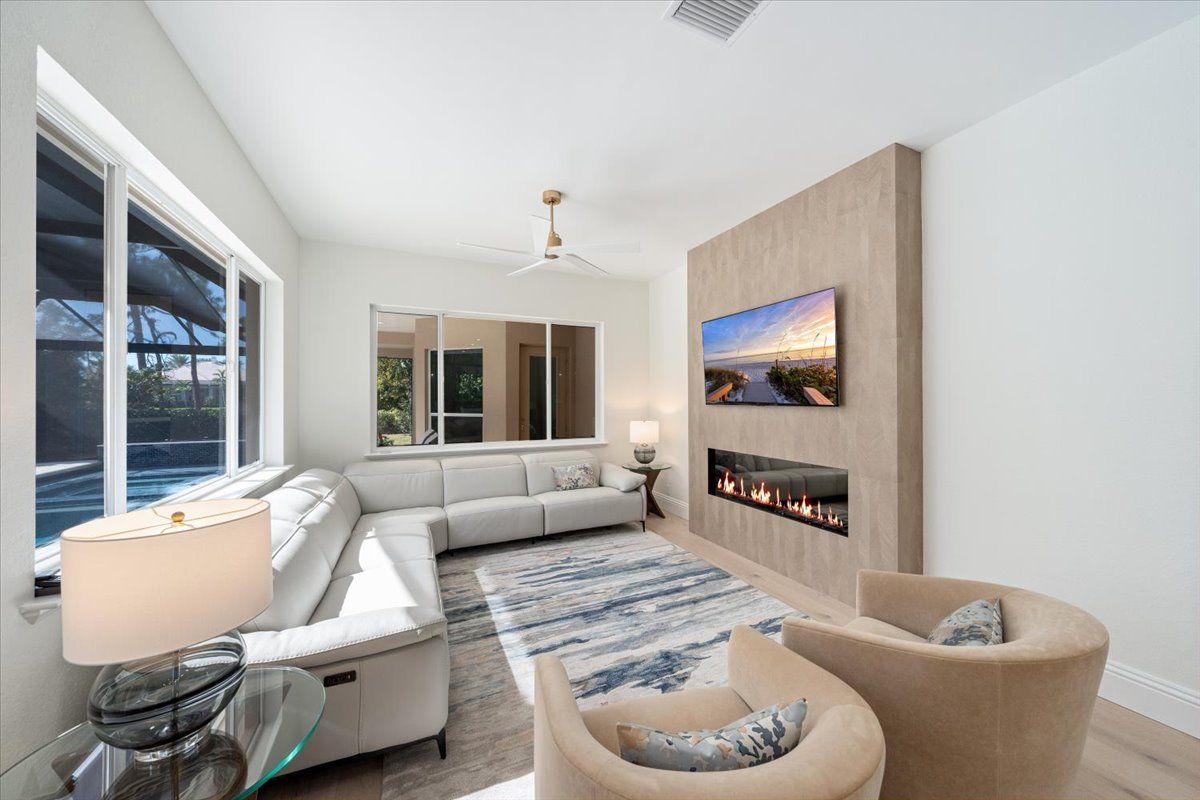 A living room with a couch, chairs, and a fireplace.