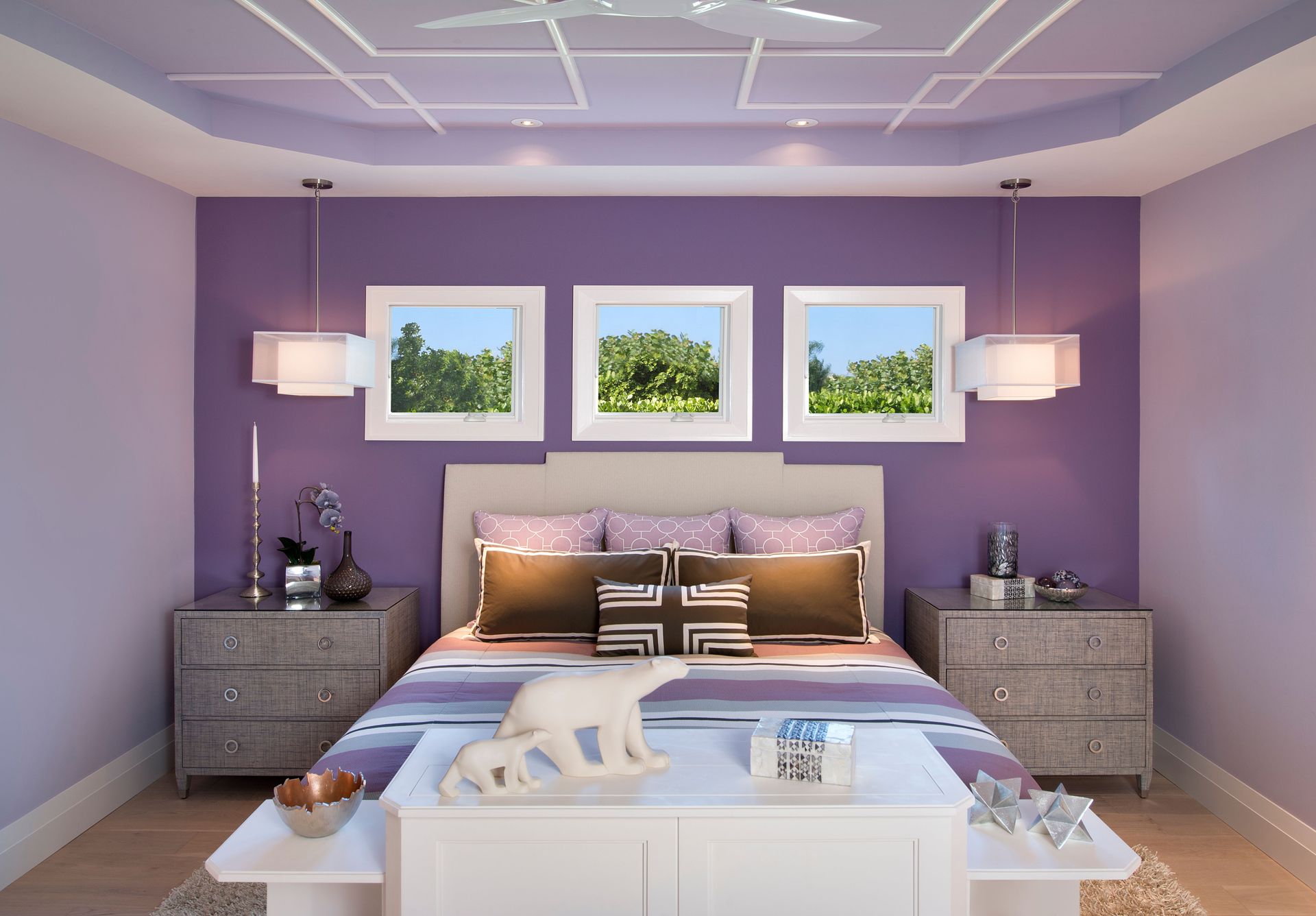 A bedroom with purple walls and a purple bed.