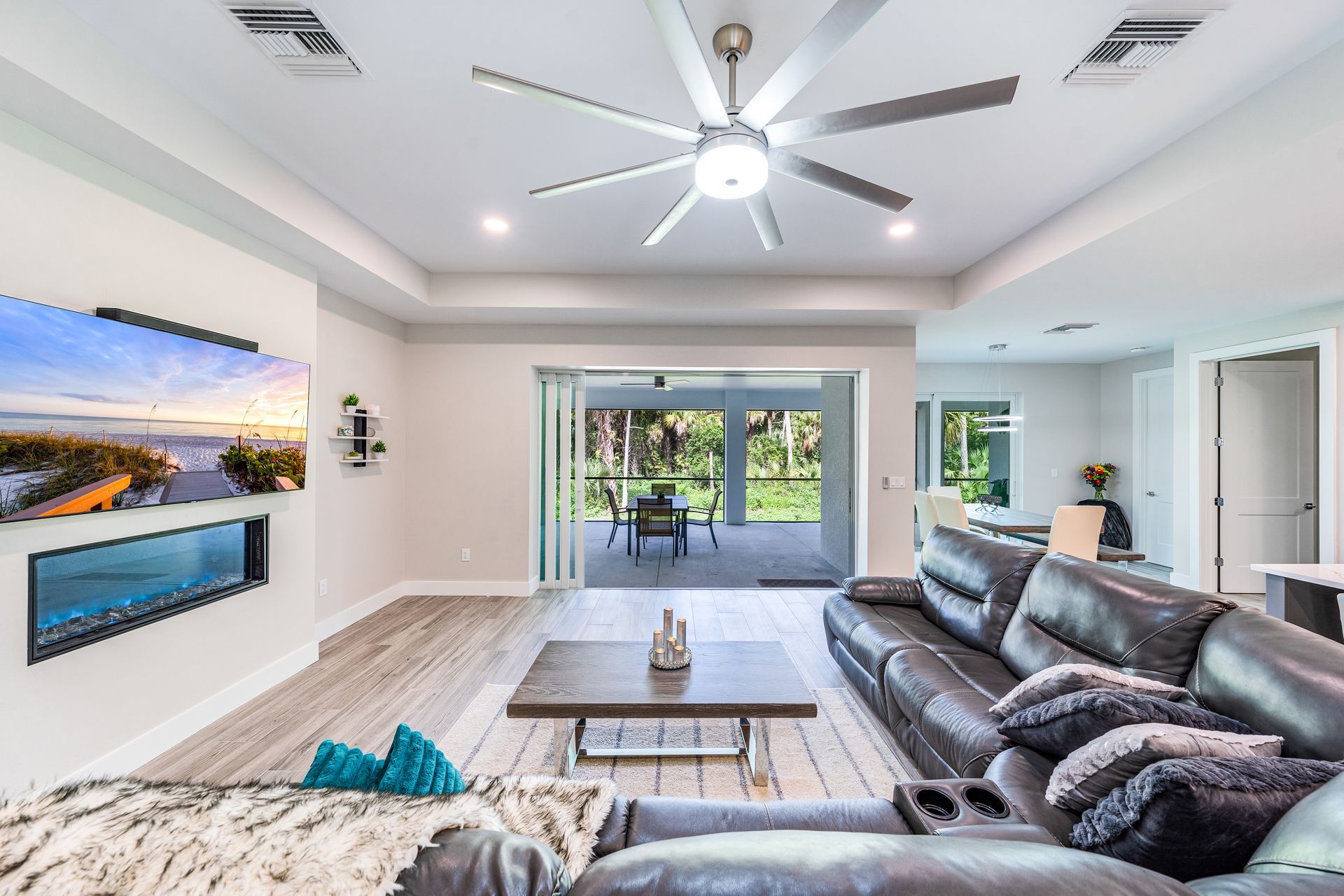 A living room with a couch, coffee table, and ceiling fan.