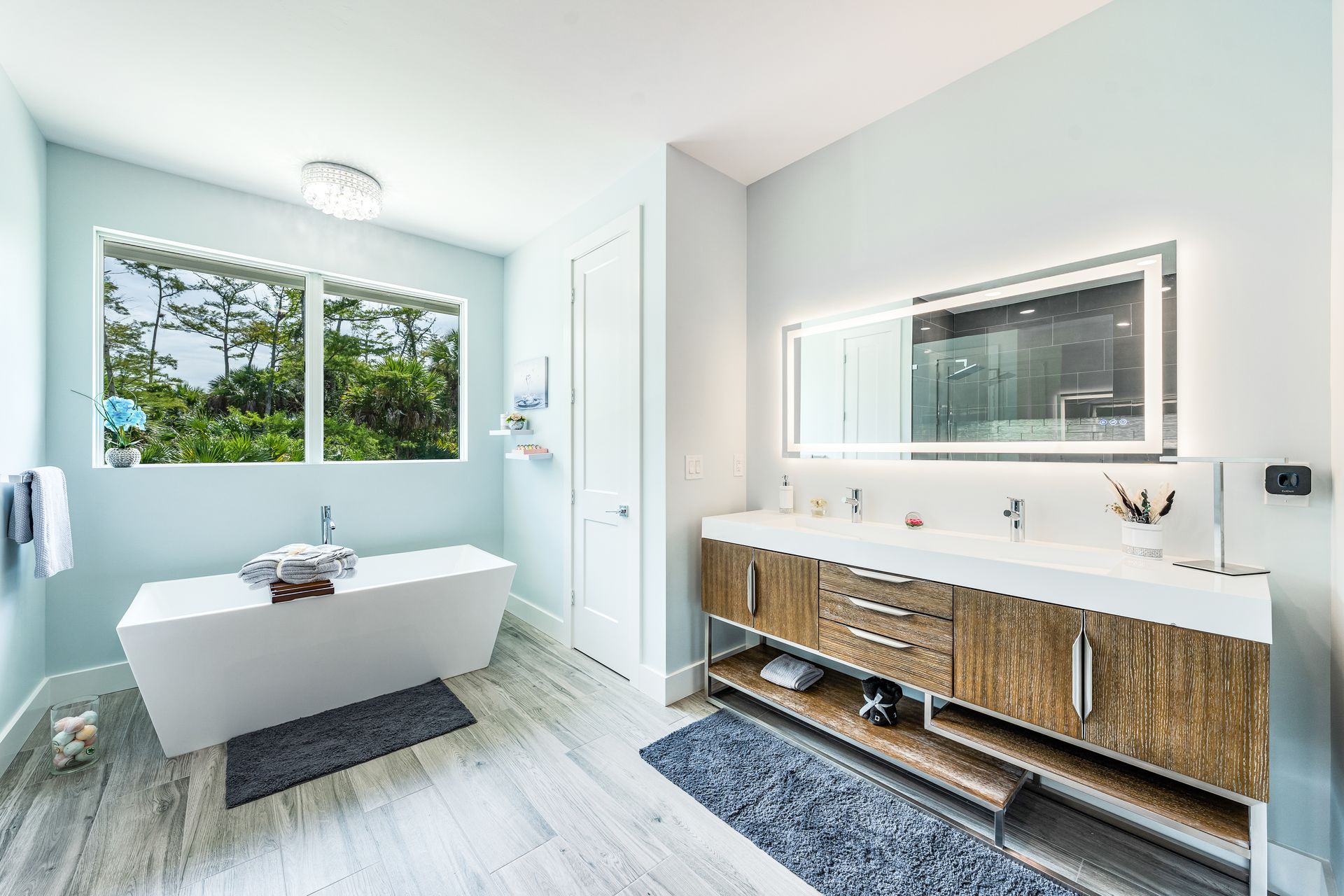 A bathroom with two sinks, a tub, and a mirror.
