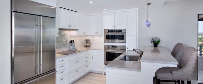 A kitchen with white cabinets and stainless steel appliances.