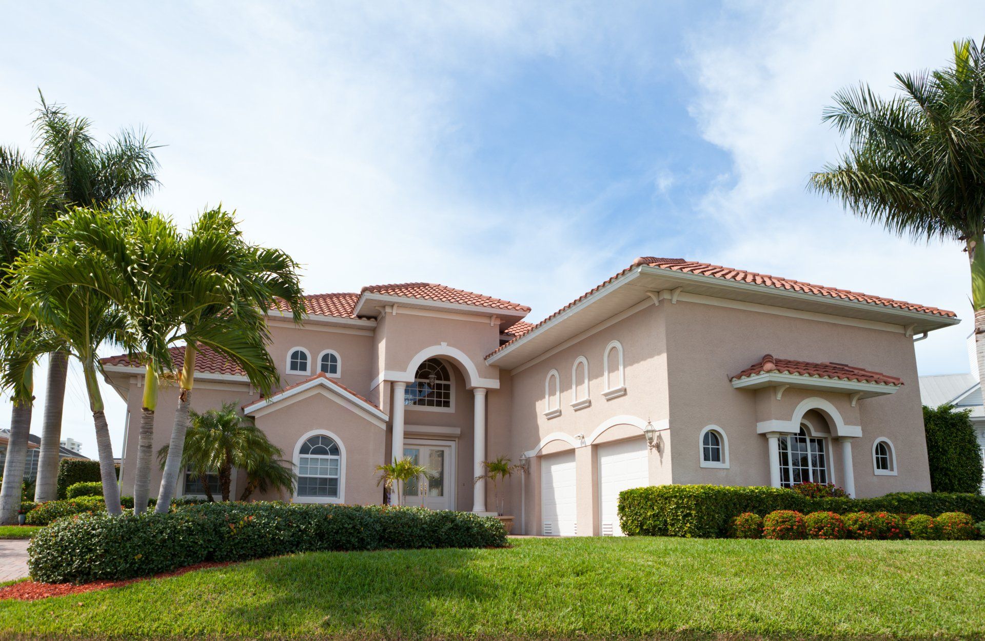 A large house with palm trees in front of it.