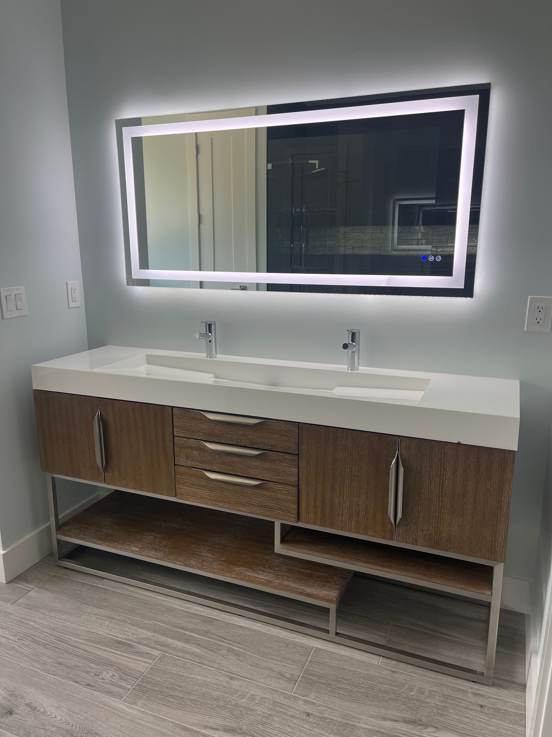 A bathroom with two sinks and a large mirror.