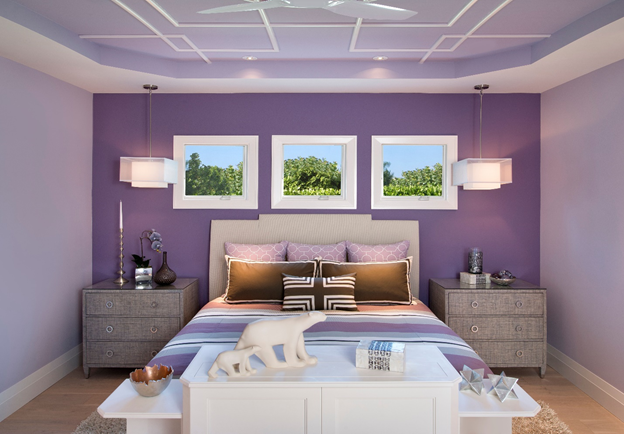 A bedroom with purple walls and a bed.