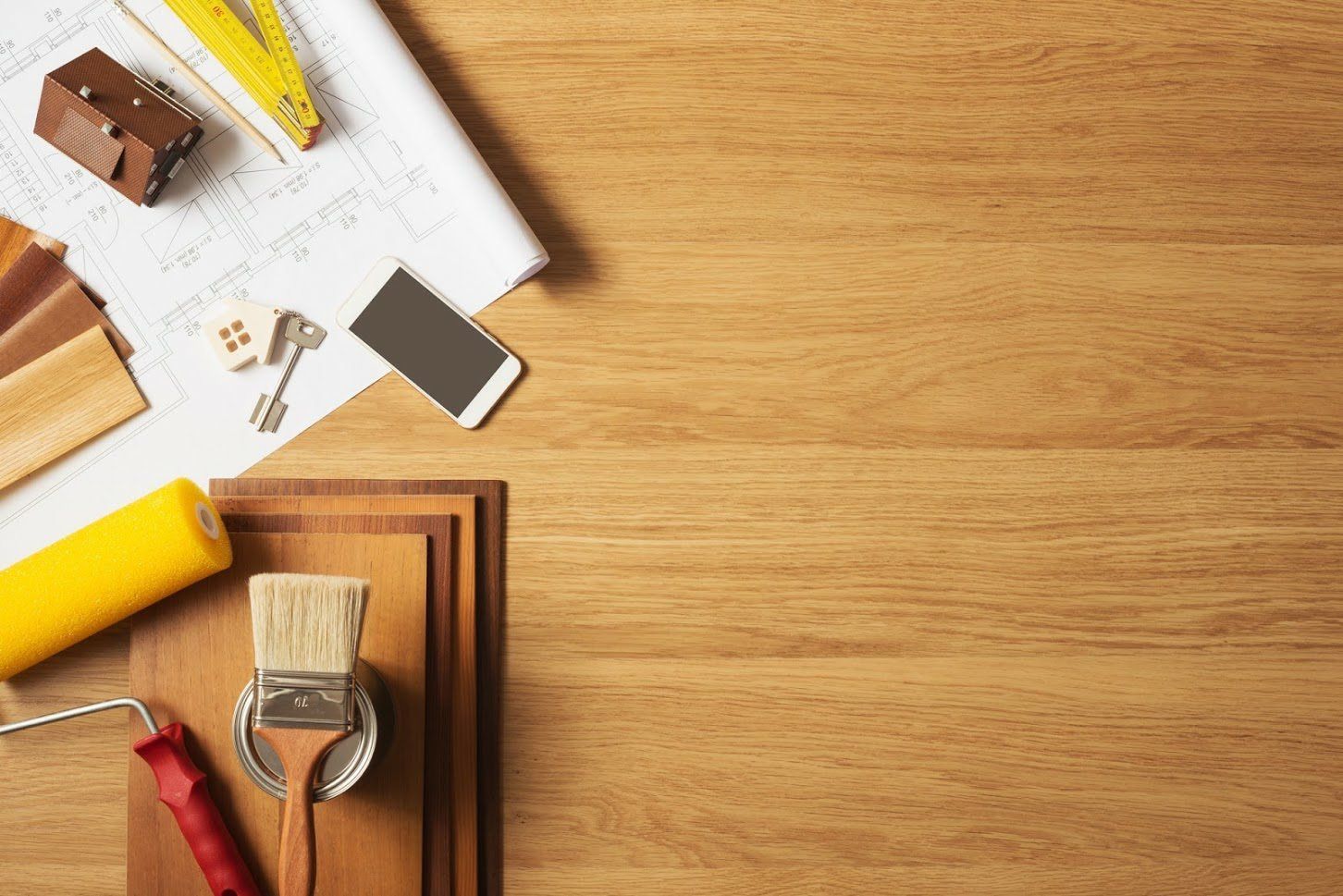 A wooden table topped with tools and a cell phone.