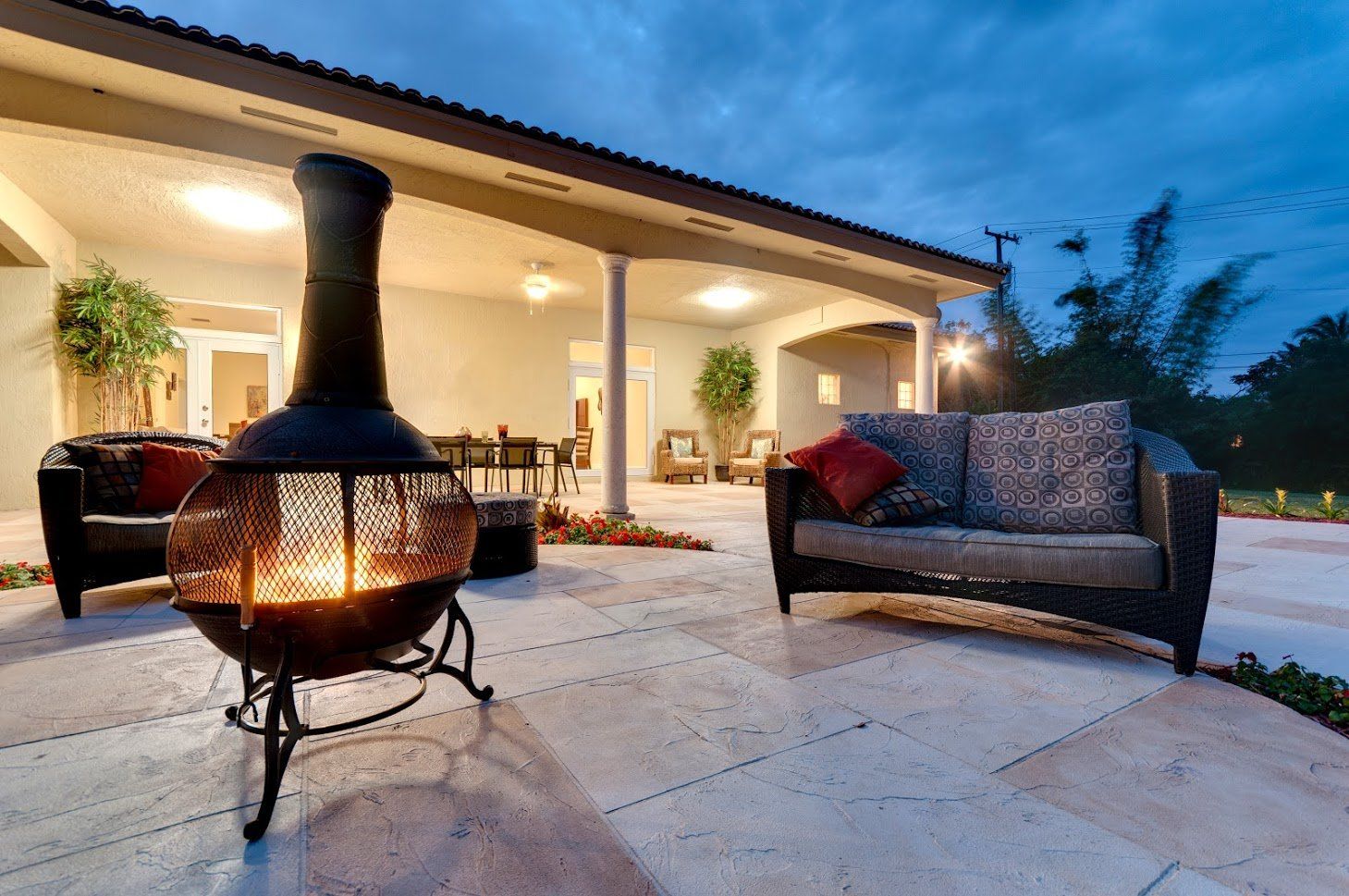 A patio with a fire pit and a couch.