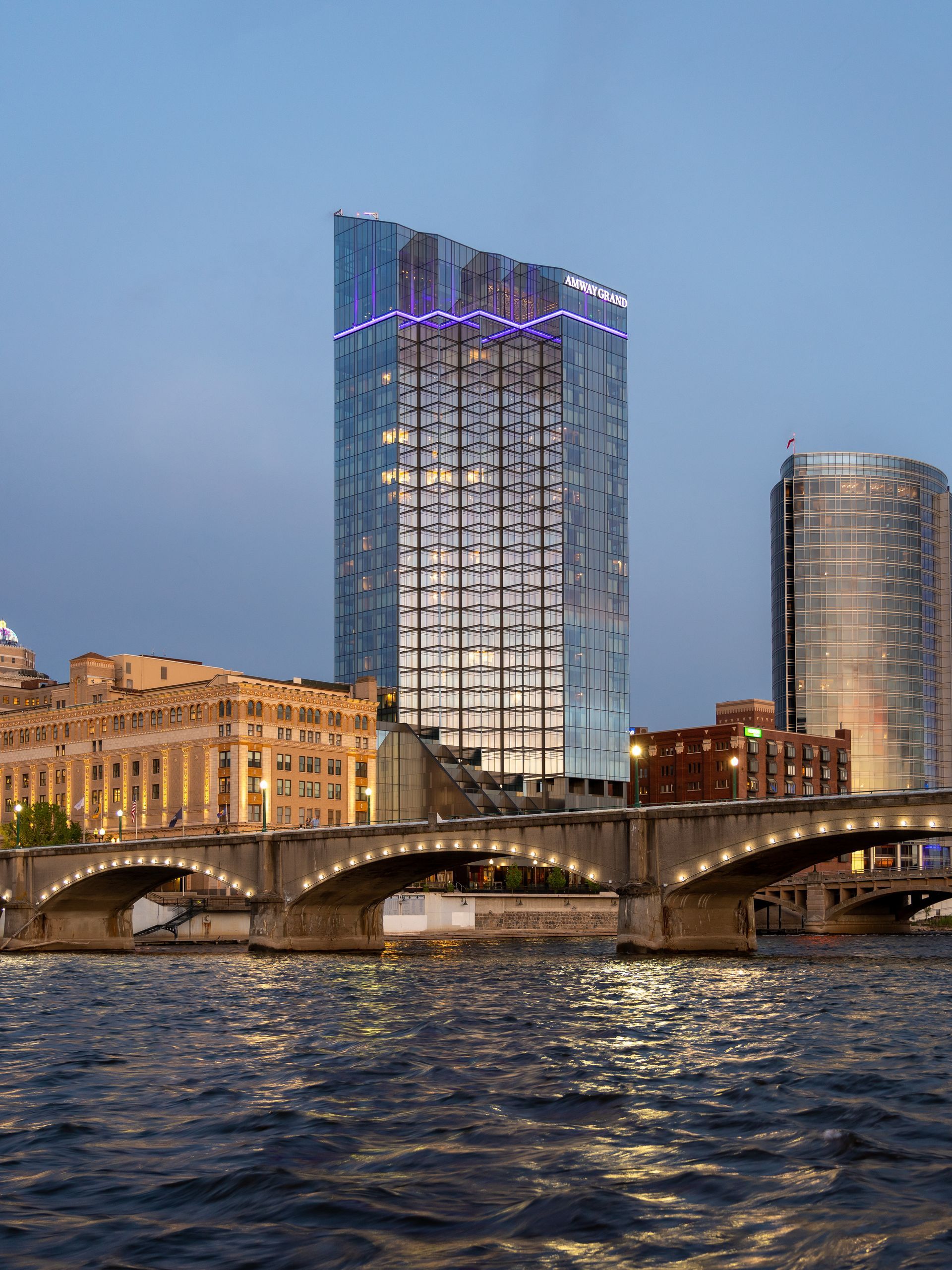 A bridge over a river with a tall building in the background