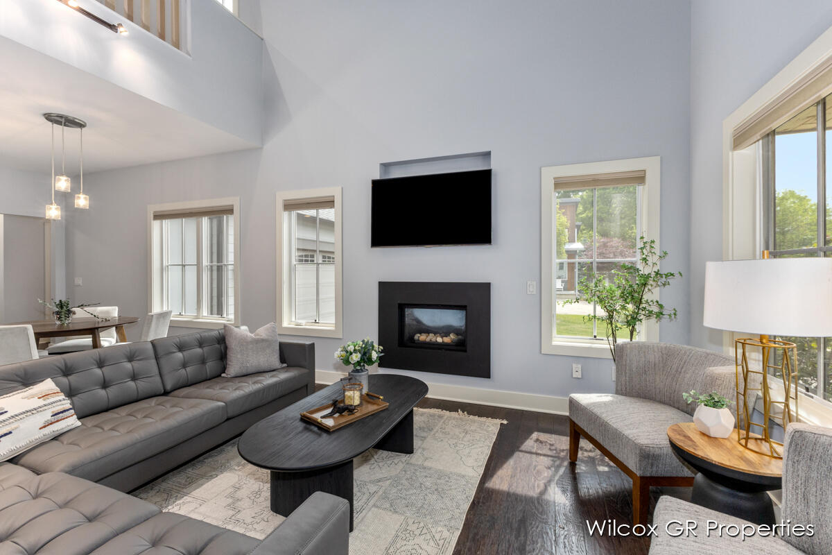 A living room with a couch , chair , coffee table , television and fireplace.