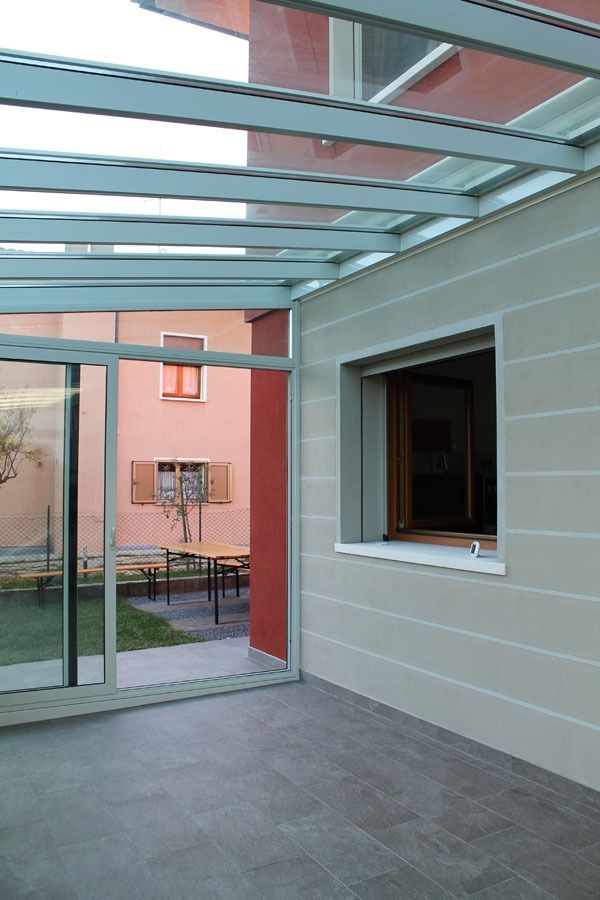 Veranda con tetto in vetro e porta scorrevole in vetro. 