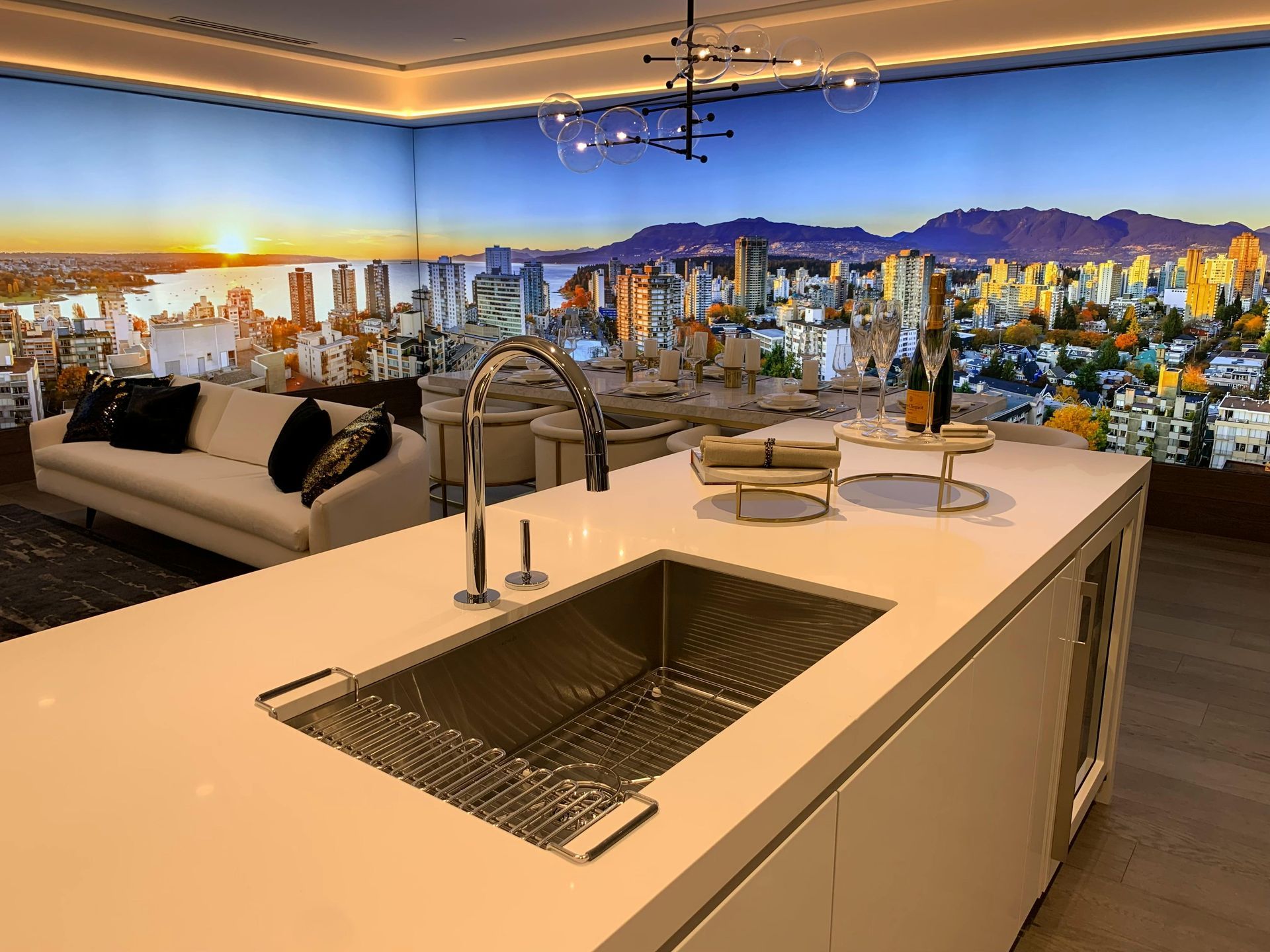 Modern kitchen with cityscape mural, white island, sink, and sofa.