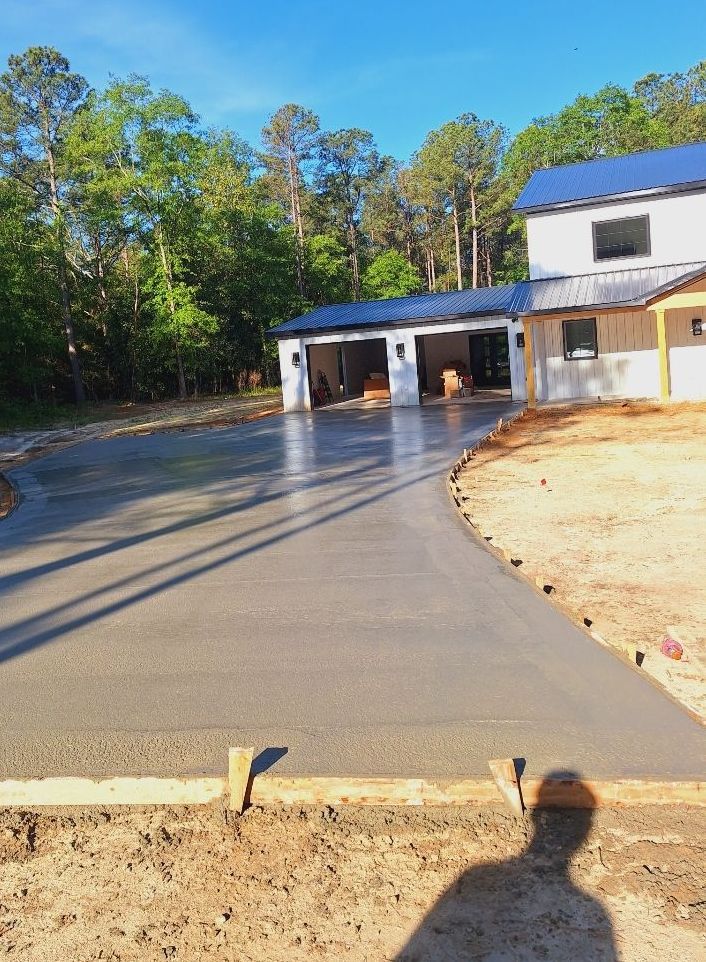 A concrete driveway is being built in front of a house.