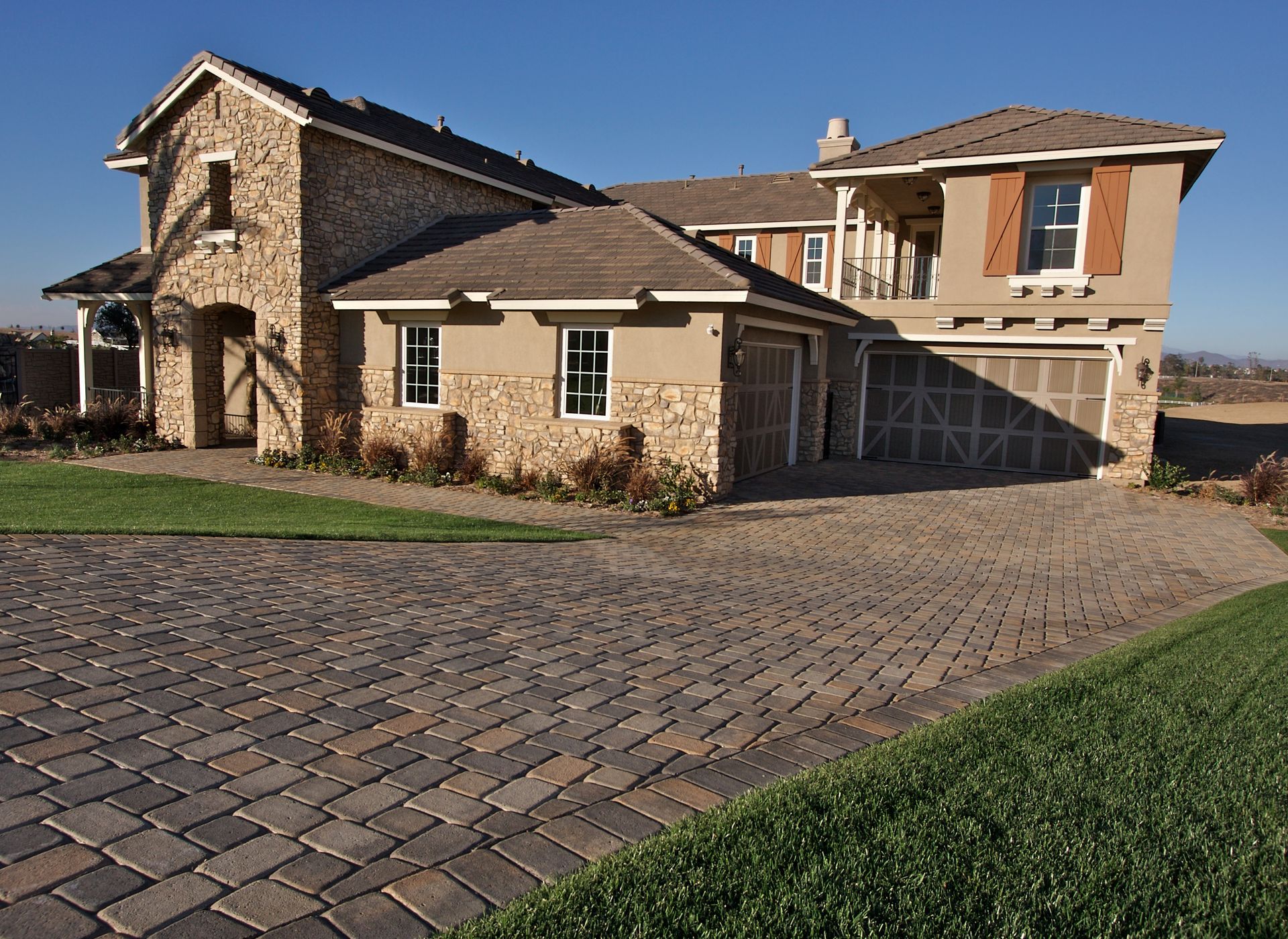 A large house with a brick driveway in front of it