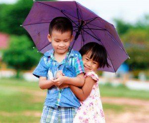 cute siblings under umbrella